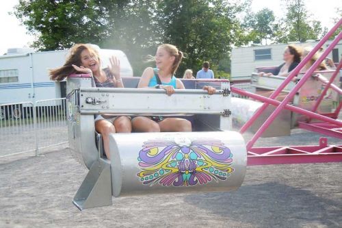 two teens enjoy one of the Crown Amusement rides at the 64th annual Verona Lions Jamboree